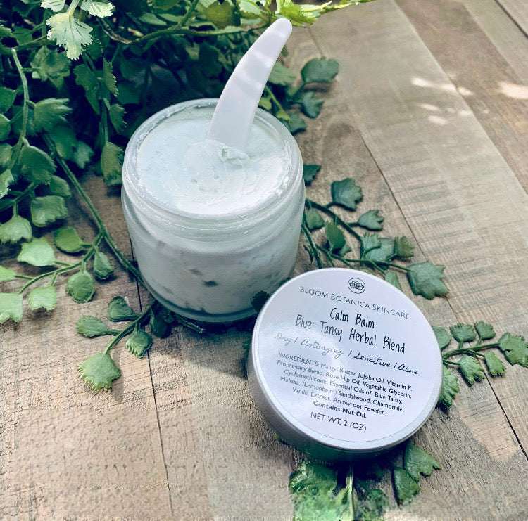 2 oz frosted glass container of creamy blue tansy calm balm. For use on the face and neck.